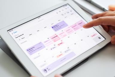 Digital calendar app open on a tablet showing medication and appointment reminders